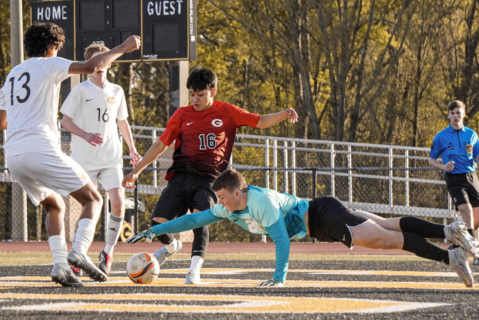 Soccer player at full stretch reaching for the ball during a match